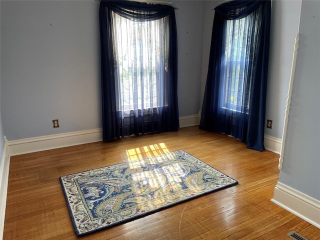 unfurnished room with hardwood / wood-style flooring