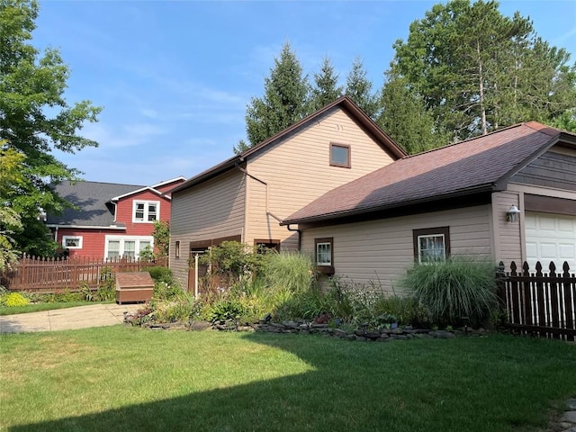 back of house with a garage and a yard