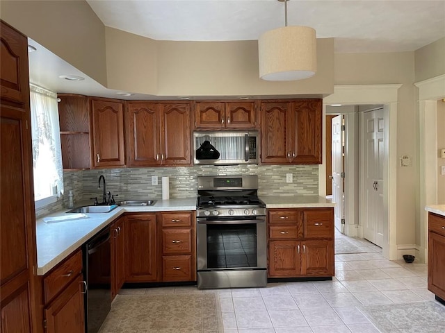 kitchen with sink, light tile patterned floors, appliances with stainless steel finishes, tasteful backsplash, and decorative light fixtures