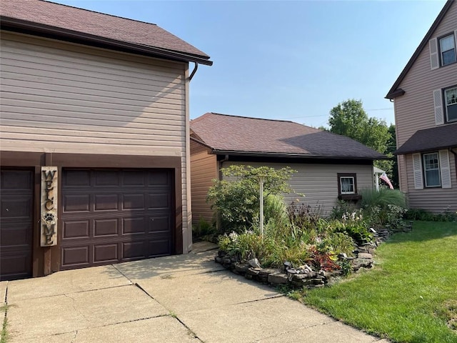 view of property exterior featuring a garage and a lawn