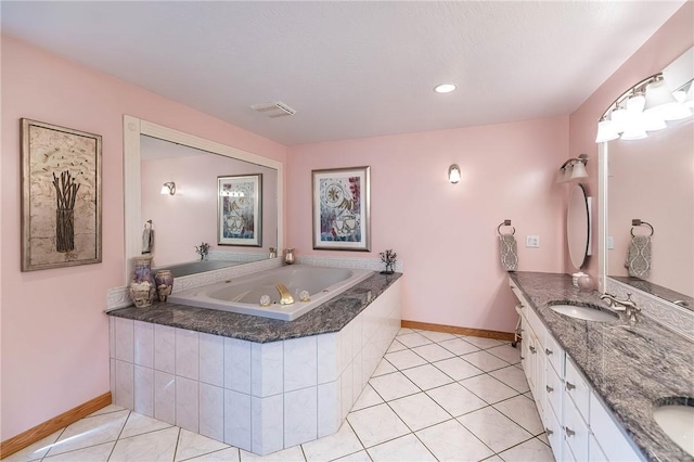 bathroom featuring tile patterned flooring, vanity, and tiled tub