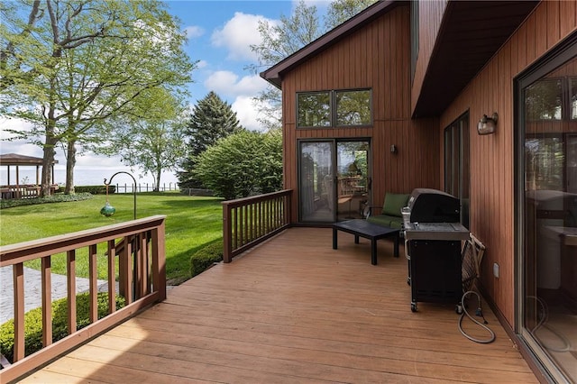 wooden terrace with a yard and area for grilling