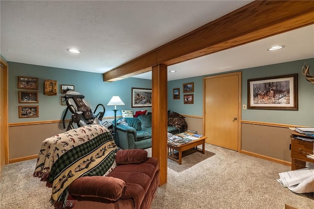 carpeted living room featuring beamed ceiling