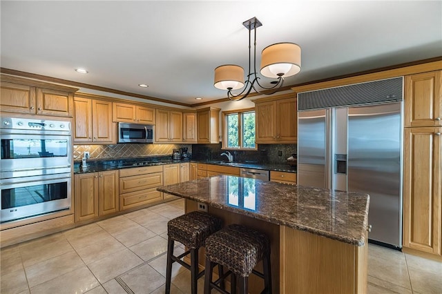 kitchen featuring pendant lighting, light tile patterned floors, ornamental molding, a kitchen island, and stainless steel appliances