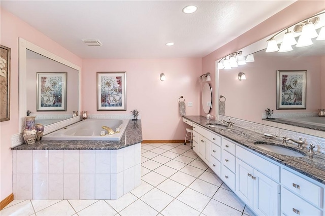 bathroom featuring tile patterned floors, tiled tub, and vanity