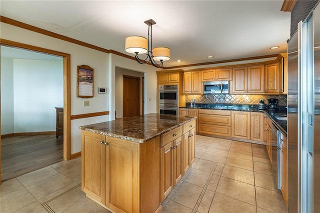 kitchen featuring decorative backsplash, appliances with stainless steel finishes, decorative light fixtures, an inviting chandelier, and a center island