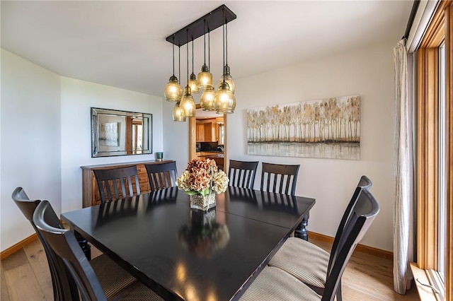 dining space featuring light hardwood / wood-style flooring and a notable chandelier