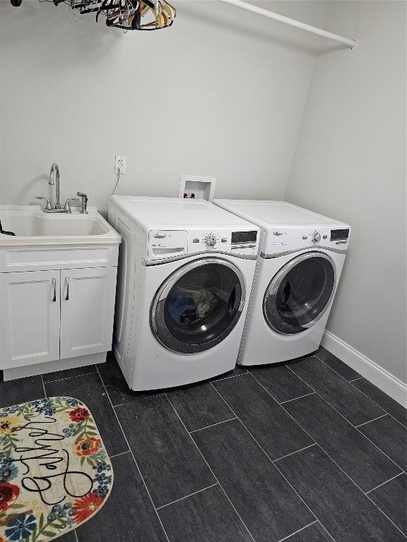 laundry room with washing machine and dryer, sink, and cabinets