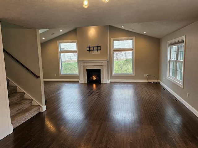 unfurnished living room featuring dark hardwood / wood-style flooring, a healthy amount of sunlight, and vaulted ceiling