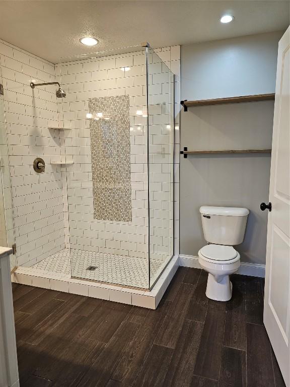 bathroom with toilet and a tile shower