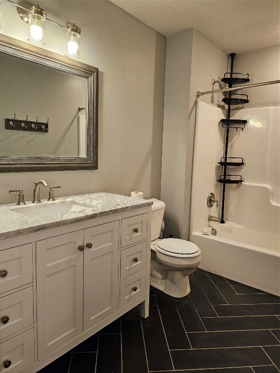 full bathroom featuring vanity,  shower combination, and toilet