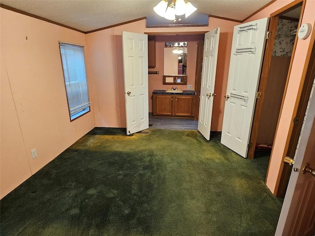 interior space featuring vaulted ceiling, dark carpet, and crown molding