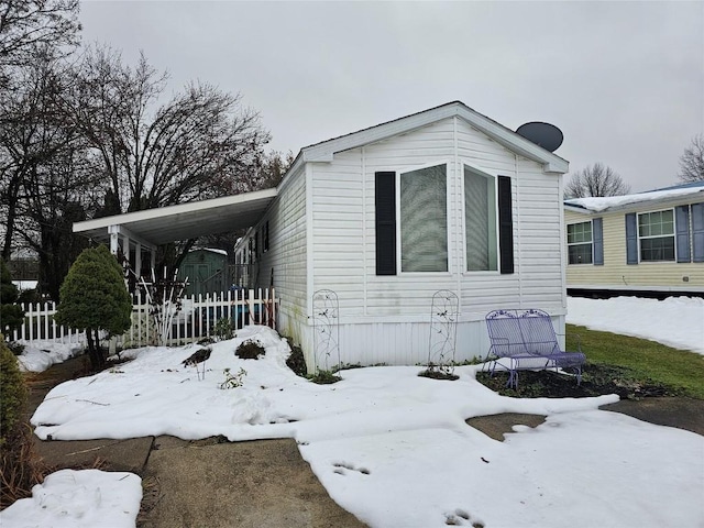 snow covered property featuring a carport