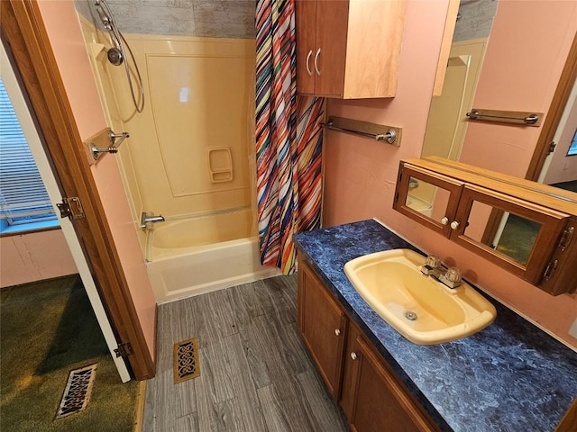 bathroom with hardwood / wood-style flooring, vanity, and shower / bath combo with shower curtain