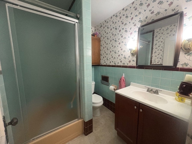 full bathroom with a shower stall, wallpapered walls, tile walls, tile patterned flooring, and wainscoting