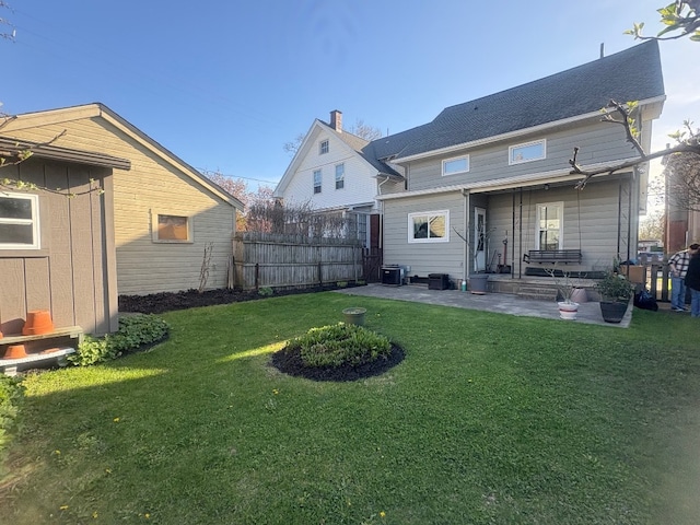 rear view of property featuring a patio, fence, cooling unit, and a yard