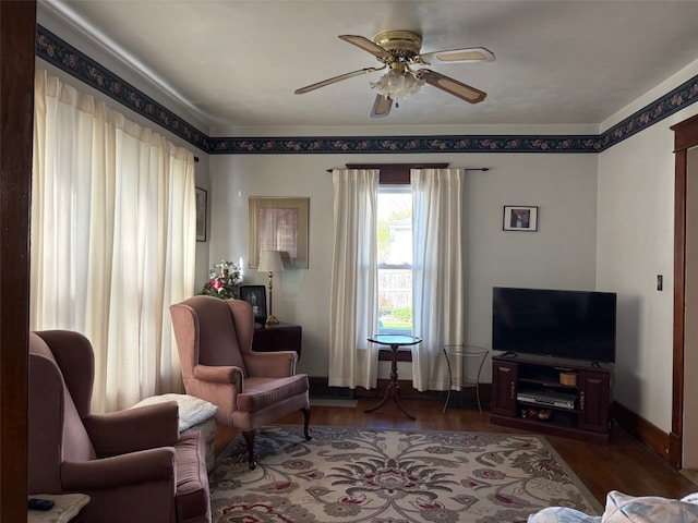 sitting room featuring a ceiling fan, wood finished floors, and baseboards