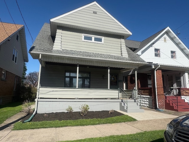 view of front of home featuring covered porch and a shingled roof