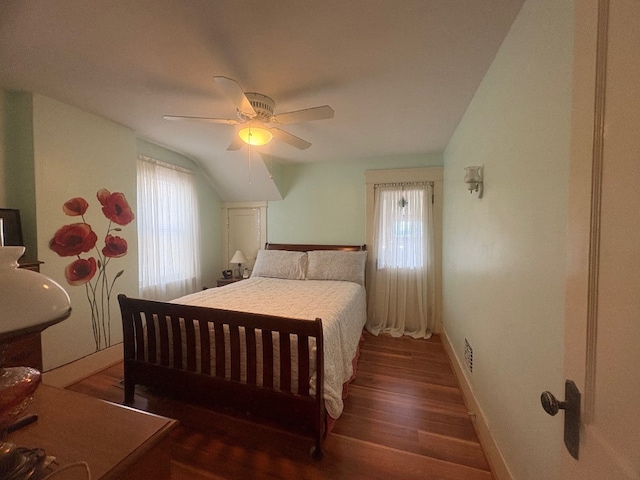 bedroom with wood finished floors, ceiling fan, visible vents, and baseboards