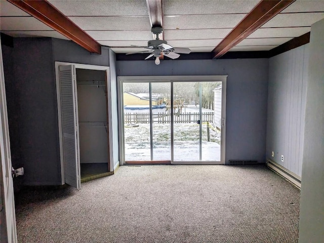 unfurnished bedroom featuring carpet, ceiling fan, beam ceiling, and wood walls