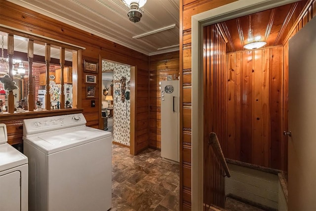 clothes washing area with wood ceiling, separate washer and dryer, and wooden walls