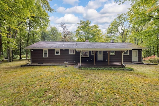 rear view of property with a yard and a patio area