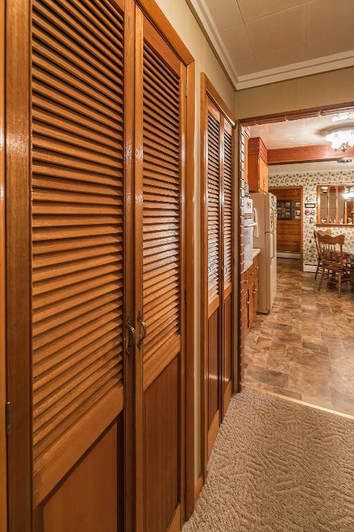 corridor with carpet floors and crown molding