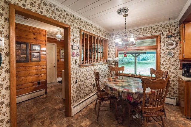 dining room with an inviting chandelier, ornamental molding, and a baseboard heating unit