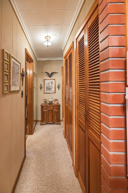 hallway with light carpet and crown molding