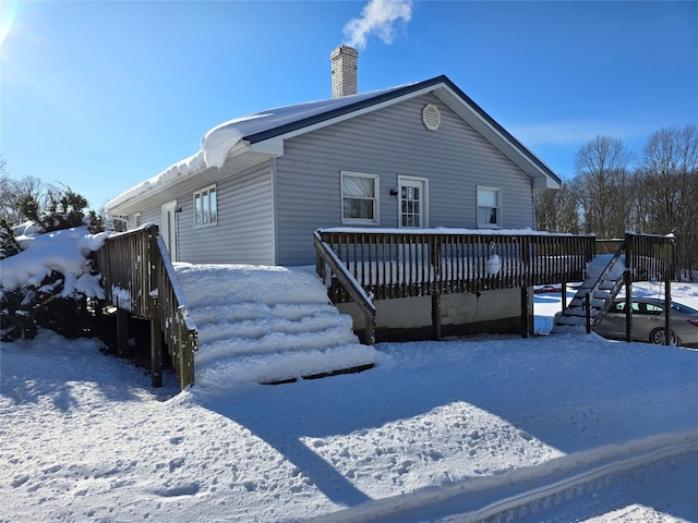 snow covered rear of property featuring a wooden deck