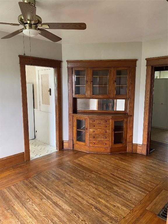 unfurnished living room with dark hardwood / wood-style floors and ceiling fan