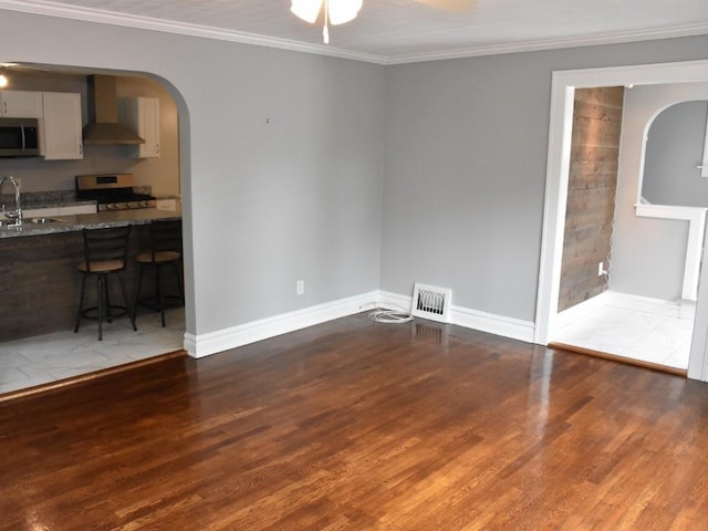 221 Locust St, Meadville, PA 16335 - unfurnished living room with wood finished floors, ceiling fan, crown molding, and arched walkways