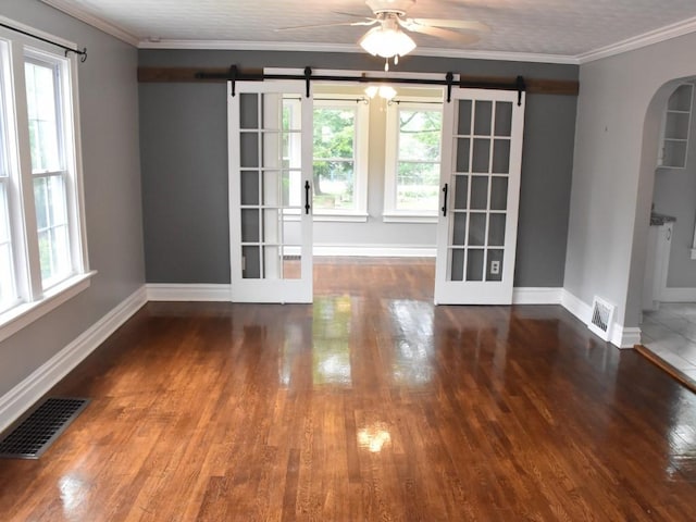 221 Locust St, Meadville, PA 16335 - unfurnished room with a barn door, wood finished floors, arched walkways, ceiling fan, and ornamental molding