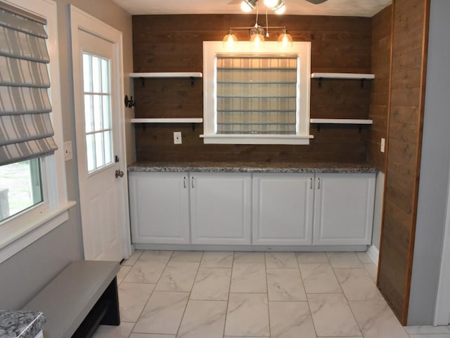 221 Locust St, Meadville, PA 16335 - unfurnished dining area with light marble finish flooring and wooden walls