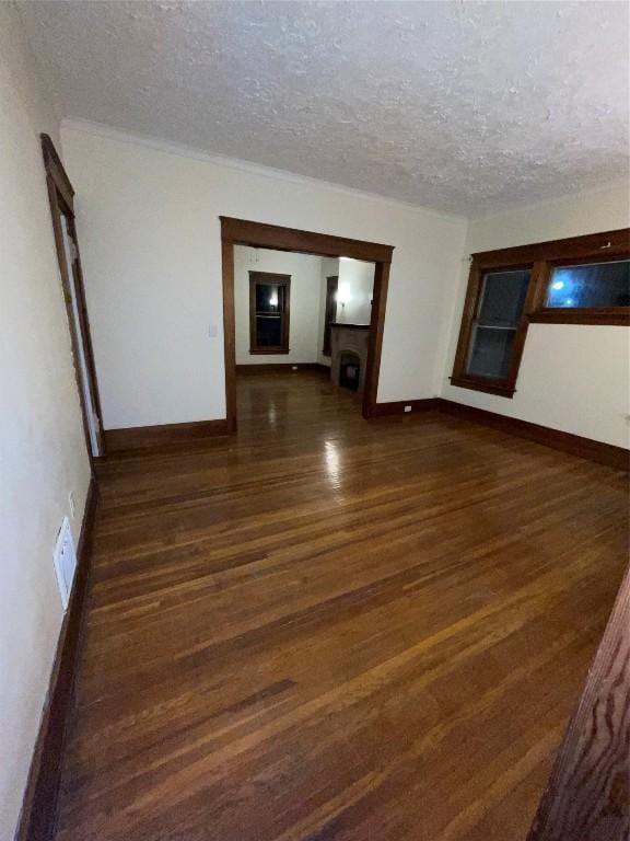 spare room with dark hardwood / wood-style floors and a textured ceiling