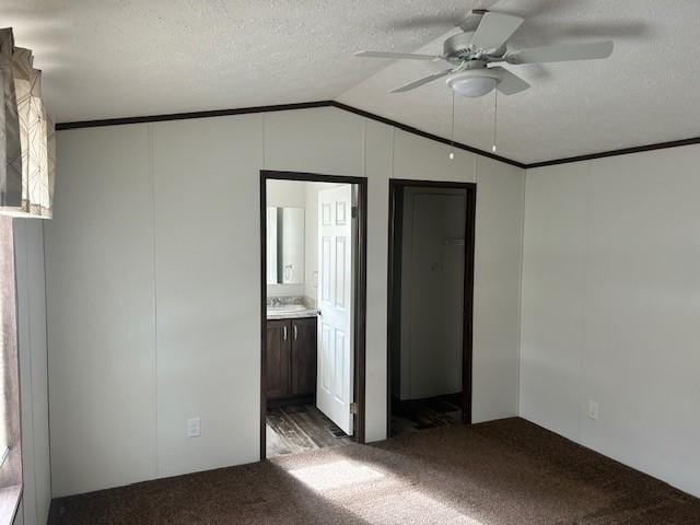 unfurnished bedroom featuring lofted ceiling, crown molding, light colored carpet, and a textured ceiling