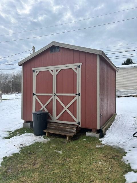 snow covered structure with a lawn