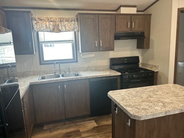 kitchen featuring crown molding, dark brown cabinets, sink, and black appliances