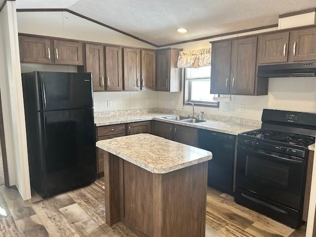 kitchen with lofted ceiling, sink, dark brown cabinetry, black appliances, and a kitchen island