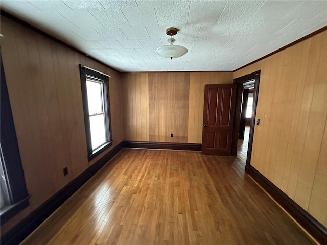 unfurnished room with wood walls and wood-type flooring