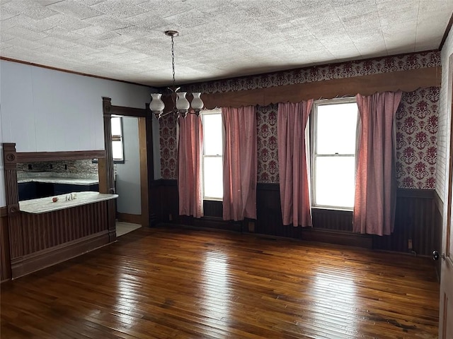 spare room with dark hardwood / wood-style floors and a chandelier