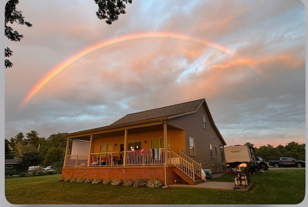 11620 Old Lake Rd, North East, PA 16428 - back of property at dusk featuring a lawn and a porch