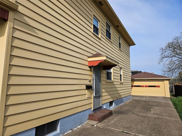 view of side of home featuring an outdoor structure and a garage