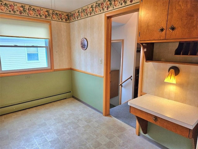 interior space with baseboards, light floors, baseboard heating, light countertops, and brown cabinets