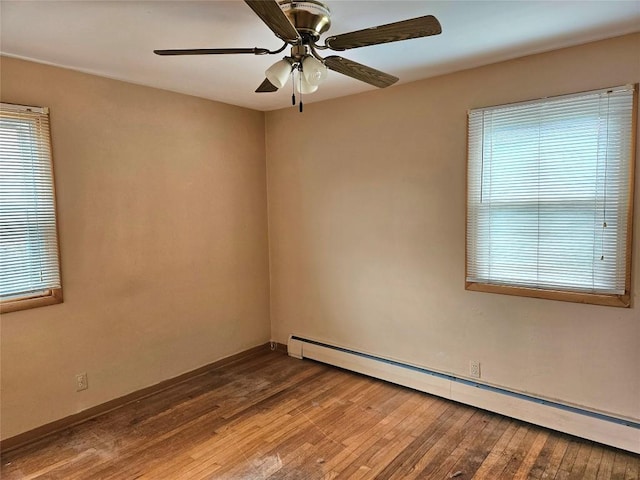 empty room with a ceiling fan, baseboards, baseboard heating, and wood finished floors