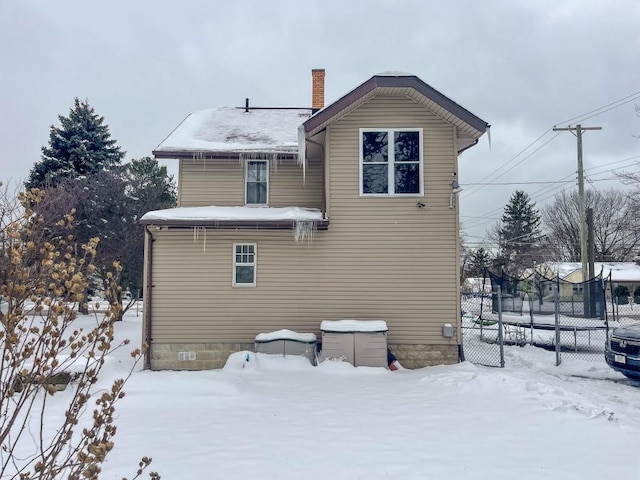 snow covered property with a trampoline