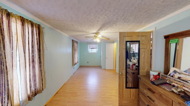 corridor featuring light hardwood / wood-style flooring and a textured ceiling