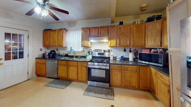 kitchen with backsplash, sink, ceiling fan, a textured ceiling, and stainless steel appliances