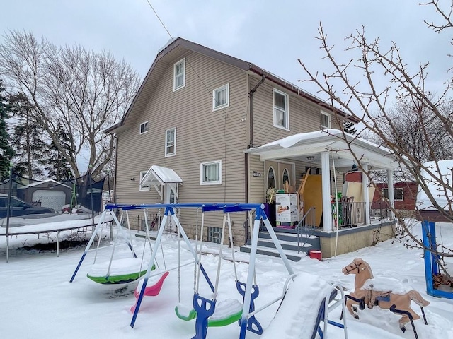 snow covered property with a trampoline