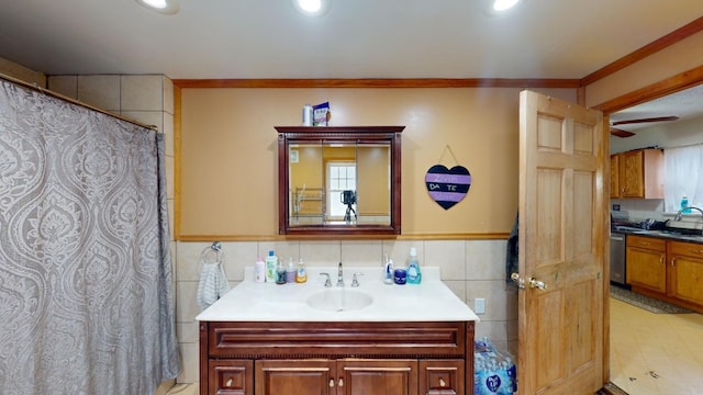 bathroom featuring ceiling fan, crown molding, and vanity